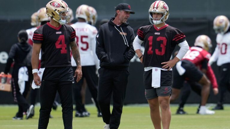 Kyle Shanahan stands with quarterbacks Adrian Martinez (4) and Brock Purdy (13) during practice Thursday, May 28, 2026, in Santa Clara, Calif. (Jeff Chiu/AP)