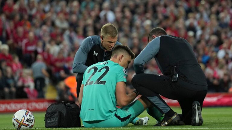 Newcastle goalkeeper Nick Pope is tended to on the pitch during a match between Liverpool and Newcastle United at Anfield, Wednesday, Aug. 31, 2022. (Jon Super/AP)