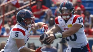 Montreal Alouettes quarterback Davis Alexander, right, hands the football off to Travis Theis during first half CFL football action against the Calgary Stampeders, in Calgary, Saturday, July 18, 2026. (Jeff McIntosh/CP)
