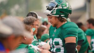 Saskatchewan Roughriders defensive back Jayden Dalke interacts with fan after a spring training scrimmage was cut short due to wildfire smoke in Saskatoon, Sask., on Saturday, May 20, 2023. (Heywood Yu/THE CANADIAN PRESS)