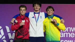 Scotland's Reuben Ward, centre, gold medal, Canada's Felix Dolci, left, silver medal and Australia's Jesse Moore, bronze medal at the men's Artistic Gymnastics all-around medal ceremony at the Commonwealth Games. (Eranga Jayawardena/AP)