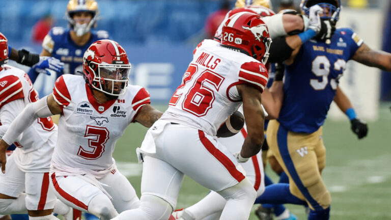 Calgary Stampeders quarterback Vernon Adams Jr. (3) hands off to Dedrick Mills (26) during first half CFL football action against the Winnipeg Blue Bombers in Winnipeg on Friday, July 24, 2026. (John Woods/CP)