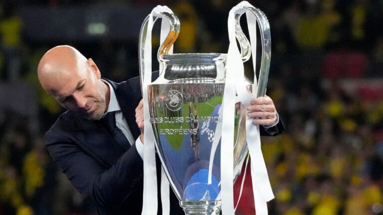 Former Real Madrid player Zinedine Zidane places the trophy on a stand for the awards ceremony after the Champions League final soccer match between Borussia Dortmund and Real Madrid at Wembley stadium in London, Sunday, June 2, 2024. (Frank Augstein/AP)