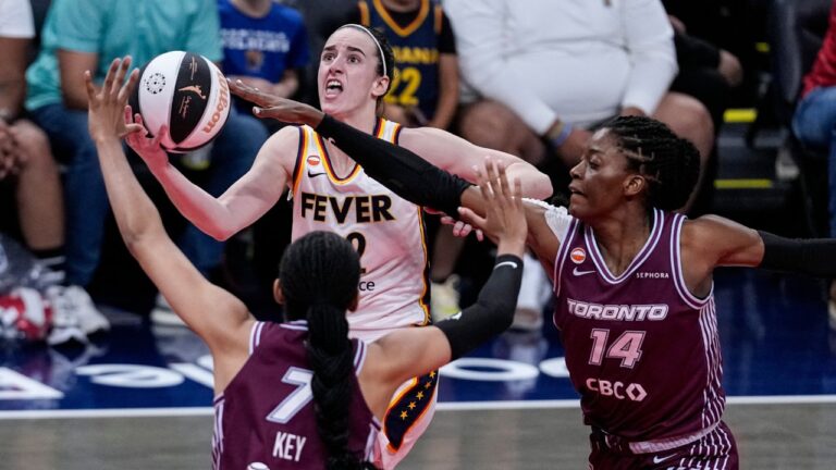 Indiana Fever guard Caitlin Clark (22) shoots over Toronto Tempo forward Teonni Key (7) and center Temi Fagbenle (14) in the first half of a WNBA Commissioner's Cup basketball game in Indianapolis, Tuesday, June 16, 2026. (AP Photo/Michael Conroy)