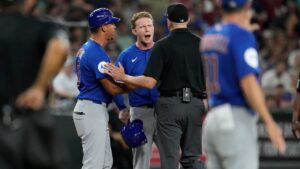 Chicago Cubs' Pete Crow-Armstrong, center, and Cubs third base coach Quintin Berry (0) argue with umpire Lance Barrett during the sixth inning of a baseball game against the Arizona Diamondbacks, Wednesday, Aug. 26, 2026, in Phoenix. (Ross D. Franklin/AP)