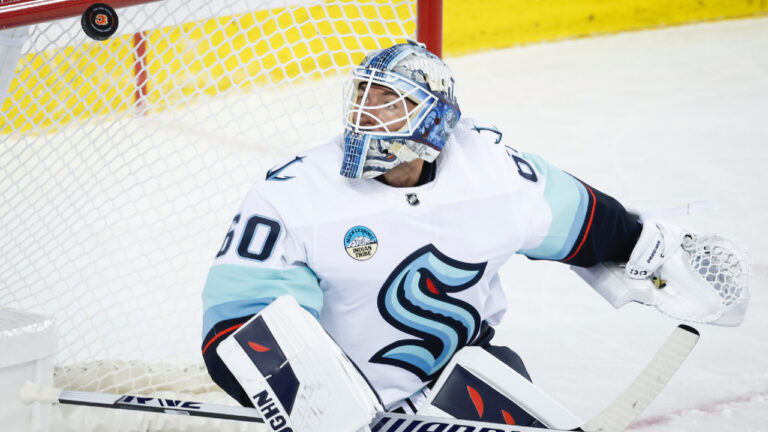 Seattle Kraken goalie Chris Driedger keeps his eyes on the puck during first period NHL preseason hockey action against the Calgary Flames in Calgary, Monday, Sept. 25, 2023. (Jeff McIntosh/CP)