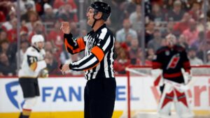 Referee Garrett Rank (7) makes a call during the second period in Game 2 of the NHL hockey Stanley Cup Final series between the Carolina Hurricanes and the Vegas Golden Knights in Raleigh, N.C., Thursday, June 4, 2026. (AP Photo/Karl DeBlaker)