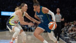Minnesota Lynx guard Kayla McBride (21) drives to the basket on Dallas Wings guard Paige Bueckers in the first half of a basketball game, Sunday Aug. 9, 2026 in Minneapolis. (Jerry Holt/Minnesota Star Tribune via AP)
