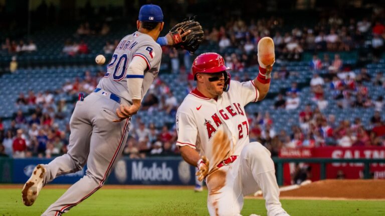 Los Angeles Angels center fielder Mike Trout (27) beats the tag at 3rd base against Texas Rangers shortstop Ezequiel Duran (20) during the 3rd inning of a baseball game, Tuesday, Aug. 11, 2026, in Anaheim, Calif. (Ethan Swope/AP)
