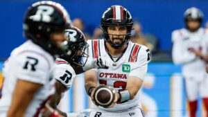 Ottawa Redblacks quarterback Jake Maier (13) hands off to Greg Bell (5) during first half CFL football action against the Winnipeg Blue Bombers in Winnipeg on Friday, August 14, 2026. (John Woods/CP)