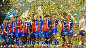 PSG's Vitinha lifts the trophy during celebrations at the end of the UEFA Super Cup soccer match between Paris Saint-Germain and Aston Villa in Salzburg, Austria, Wednesday, Aug.12, 2026. (Darko Bandic/AP)