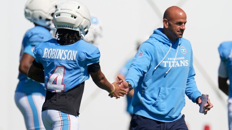 Tennessee Titans head coach Robert Saleh, right, greets wide receiver Wan'dale Robinson (4) during the NFL football team's training camp Tuesday, Aug. 25, 2026, in Nashville, Tenn. (AP Photo/George Walker IV)