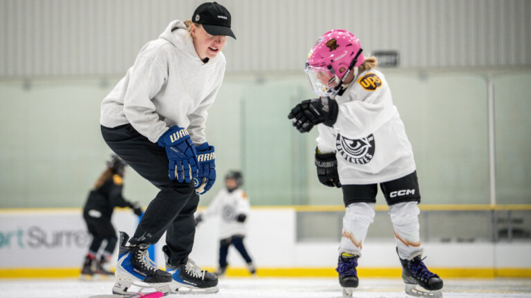 Vancouver Goldeneyes' Ashton Bell, coaches a girl during a youth summer hockey camp in Surrey, B.C., on Monday, Aug. 17, 2026. (Ethan Cairns/CP)