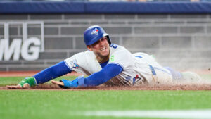 Toronto Blue Jays' George Springer (4) slides in to score on an RBI single by Andres Gimenez (0) during sixth inning MLB baseball action against the Boston Red Sox in Toronto, on Monday, Aug. 10, 2026. (Sammy Kogan/CP)