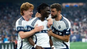 Vancouver Whitecaps' Emmanuel Sabbi, centre, celebrates his goal against FC Dallas with Oliver Larraz, left, and Thomas Muller during the first half of an MLS soccer match in Vancouver, on Saturday, August 22, 2026. (Ethan Cairns/CP)