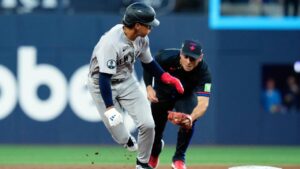 New York Yankees shortstop George Lombard Jr. (96) gets caught in a rundown as Toronto Blue Jays shortstop Andrés Giménez (0) chases during first inning MLB baseball action in Toronto on Friday, Aug. 14, 2026. (Chris Young/CP)