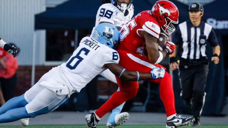 Toronto Argonauts' Adarius Pickett (6) tackles Calgary Stampeders' Dedrick Mills during second half CFL football action in Calgary, Thursday, July 2, 2026. (Jeff McIntosh/THE CANADIAN PRESS)