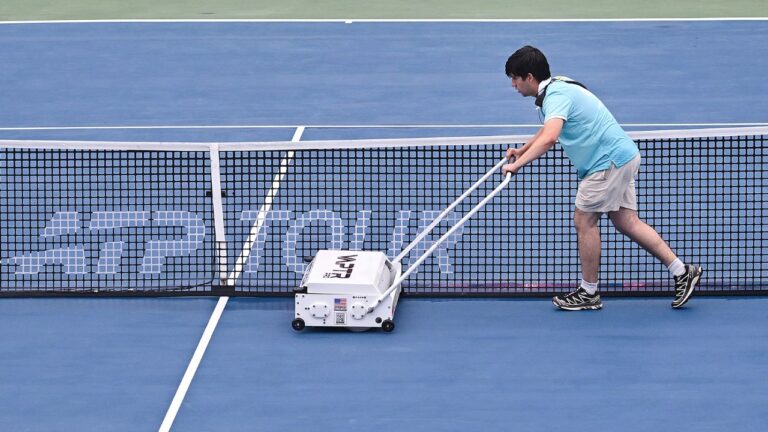 A ground crew member dries centre court during a rain delay at the National Bank Open tennis tournament in Montreal, on Sunday, Aug. 2, 2026. (Graham Hughes/THE CANADIAN PRESS)