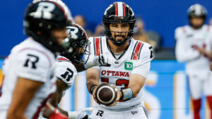 Ottawa Redblacks quarterback Jake Maier (13) hands off to Greg Bell (5) during first half CFL football action against the Winnipeg Blue Bombers in Winnipeg on Friday, August 14, 2026. (John Woods/CP)