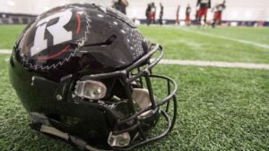 An Ottawa Redblacks helmet sits on the sideline at practice for the 104th Grey Cup in Toronto. (Frank Gunn/THE CANADIAN PRESS)