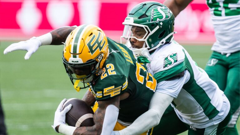Edmonton Elks' Javon Leake (22) is tackled by Saskatchewan Roughriders' Marcus Sayles (8) during first half CFL football action in Edmonton on Saturday, August 1, 2026. (Codie McLachlan/THE CANADIAN PRESS)