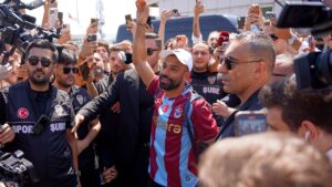 Egypt's Mohamed Salah wearing his new Trabzonspor team jersey gestures to supporters as he arrives at the airport in Istanbul, Turkey, Wednesday, Aug. 5, 2026. (Samet Yalcin/DIA Photo via AP)