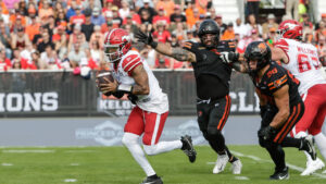 Calgary Stampeders quarterback Vernon Adams Jr. (3) runs under pressure from B.C. Lions' Levi Bell (98) during first half CFL football action in Kelowna, B.C., on Saturday, June 27, 2026. (Steve Dunsmoor/CP)