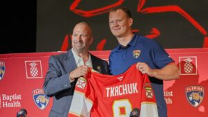 Florida Panthers general manager Bill Zito, left, and Brady Tkachuk holds his jersey as the new member of the team Tuesday, June 23, 2026, in Fort Lauderdale, Fla. (Marta Lavandier/AP Photo)