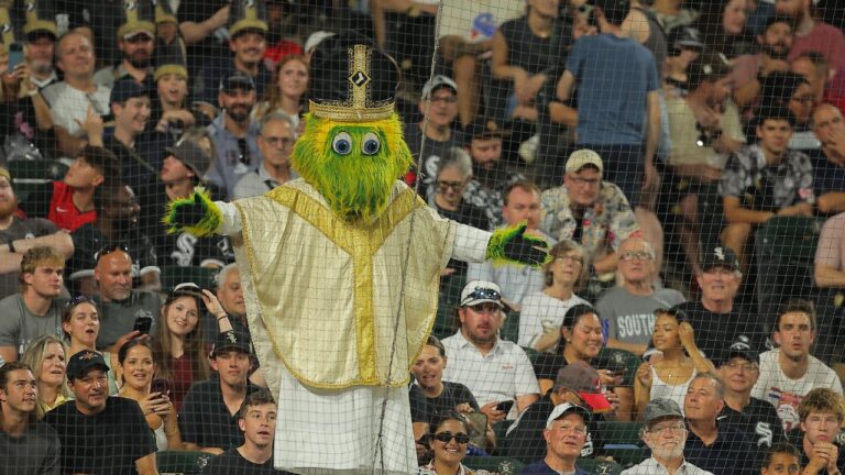 Chicago White Sox mascot Southpaw stands on the dugout wearing a pope outfit during the seventh inning of a baseball game against the Cincinnati Reds, Tuesday, Aug. 11, 2026, in Chicago. (Melissa Tamez/AP)