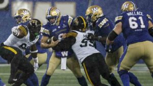 Winnipeg Blue Bombers quarterback Zach Collaros (8) gets sacked by Hamilton Tiger-Cats' Julian Howsare (95) during second half CFL football action in Winnipeg on Thursday, June 11, 2026. (John Woods/CP)