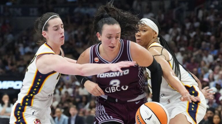 Toronto Tempo's Marina Mabrey (centre) drives between Indiana Fever's Caitlin Clark (left) and Makayla Timpson (21) during second half WNBA basketball action in Toronto on Tuesday, August 18, 2026. (Chris Young/CP)