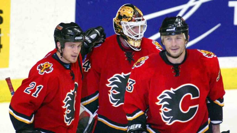 Calgary Flames Andrew Ference (left) Miikka Kiprusoff (centre) and Kryztof Oliwa celebrate thier win over the Detroit Red Wings following NHL playoff action in Calgary, Tuesday, April 27, 2004. (Jeff McIntosh/CP)