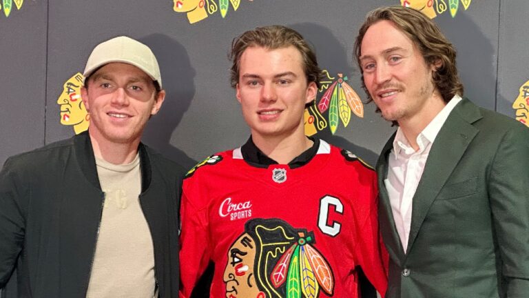 In this photo taken with a smartphono, Chicago Blackhawks players, from left, Patrick Kane, Connor Bedard and Tyler Bertuzzi pose during a news conference introducing Bedard as the new captain of the NHL hockey club, Tuesday, Sept. 15, 2026, in Chicago. (Jay Cohen/AP)