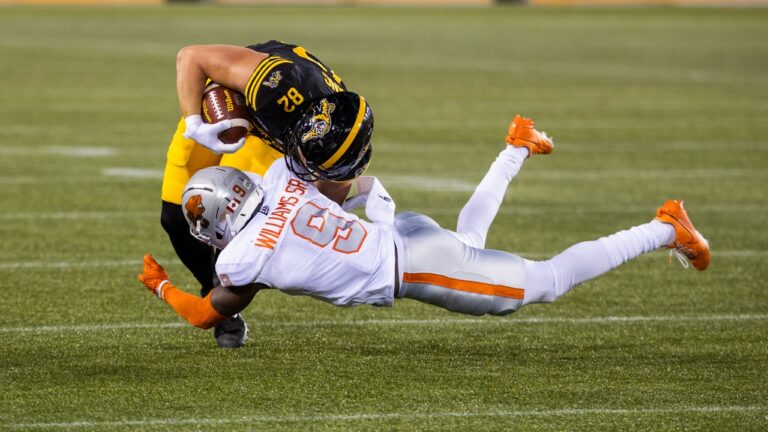 Hamilton Tiger-Cats' Maximilian Mang (82) is taken down by B.C. Lions' Deontai Williams (9) during second half CFL football action in Hamilton on Friday, June 19, 2026. (Nick Iwanyshyn/CP)
