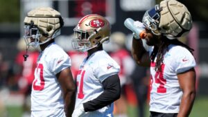 San Francisco 49ers linebackers Jalen Graham, left, Kyahva Tezino, middle, and Fred Warner stand on the field during the NFL team's football training camp in Santa Clara, Calif., Thursday, July 27, 2023. (AP Photo/Jeff Chiu)