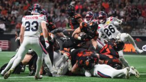 B.C. Lions' Zander Horvath dives over the pile of players and the goal line to score his third touchdown during the second half of a CFL football game against the Montreal Alouettes, in Vancouver, on Saturday, Sept. 12, 2026. (Darryl Dyck/CP)