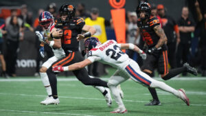 B.C. Lions quarterback Nathan Rourke (12) runs the ball for a first down past Montreal Alouettes' Nate Beauchemin (23) during the first half of a CFL game, in Vancouver, on Saturday, Sept. 12, 2026. (Darryl Dyck/CP)