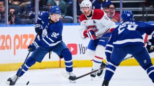 Toronto Maple Leafs' Gavin McKenna (92) moves the puck past Montreal Canadiens' Mike Matheson (8) during first period NHL pre-season hockey action in Toronto, on Saturday, Sept. 19, 2026. THE CANADIAN PRESS/Sammy Kogan