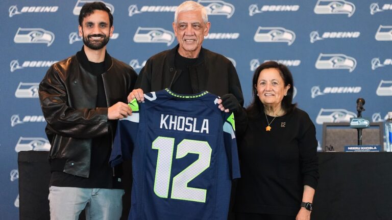 Seattle Seahawks owners, from left, Vice Chair Neal Khosla, Chair Vinod Khosla and Controlling Owner & President of the Seahawks Charitable Foundation Neeru Khosla pose with a Seahawks jersey before a news conference before an NFL football game between the Seahawks and the New England Patriots, Wednesday, Sept. 9, 2026, in Seattle. (AP Photo/Lindsey Wasson)