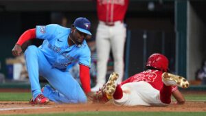 Texas Rangers' Nicky Lopez, right, slides under the tag of Toronto Blue Jays starting pitcher José Soriano while scoring on a wild pitch during the second inning of a baseball game Saturday, Sept. 19, 2026, in Arlington, Texas. (Julio Cortez/AP)