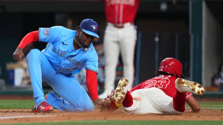 Texas Rangers' Nicky Lopez, right, slides under the tag of Toronto Blue Jays starting pitcher José Soriano while scoring on a wild pitch during the second inning of a baseball game Saturday, Sept. 19, 2026, in Arlington, Texas. (Julio Cortez/AP)