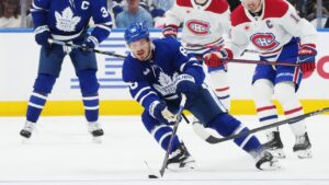 Toronto Maple Leafs' Jack Roslovic (96) protects the puck from Montreal Canadiens' Nick Suzuki (14) during first period NHL hockey action in Toronto on Tuesday, Sept. 29, 2026. (Nathan Denette/CP)