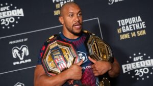 Ciryl Gane holds his championship belts at a press conference following the UFC Freedom 250 fight, Monday, June 15, 2026, in Washington. (AP Photo/Allison Robbert)