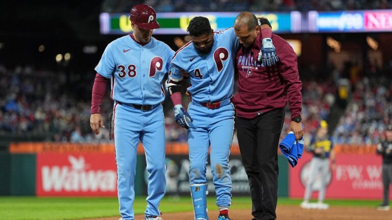 Philadelphia Phillies' Luis Arraez (4) is helped off the field after being injured during the sixth inning of a baseball game against the Milwaukee Brewers, Thursday, Sept. 24, 2026, in Philadelphia. (AP Photo/Matt Rourke)