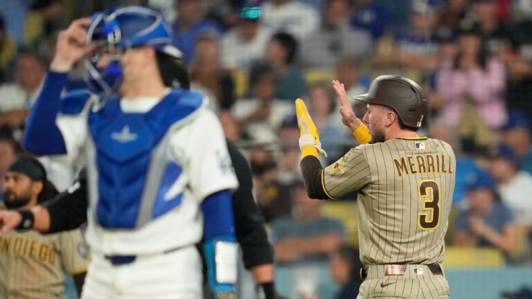 San Diego Padres' Jackson Merrill, right, claps after scoring on a single by Austin Hays as Los Angeles Dodgers catcher Hunter Feduccia stands by during the seventh inning of a baseball game Thursday, Sept. 24, 2026, in Los Angeles. (AP Photo/Mark J. Terrill)