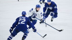 Toronto Maple Leafs' Gavin McKenna (92), centre, keeps the puck from Jake McCabe (22) and Steven Lorentz (18) during the opening week of the team's NHL training camp in Toronto, on Thursday, Sept. 17, 2026. (Sammy Kogan/CP)