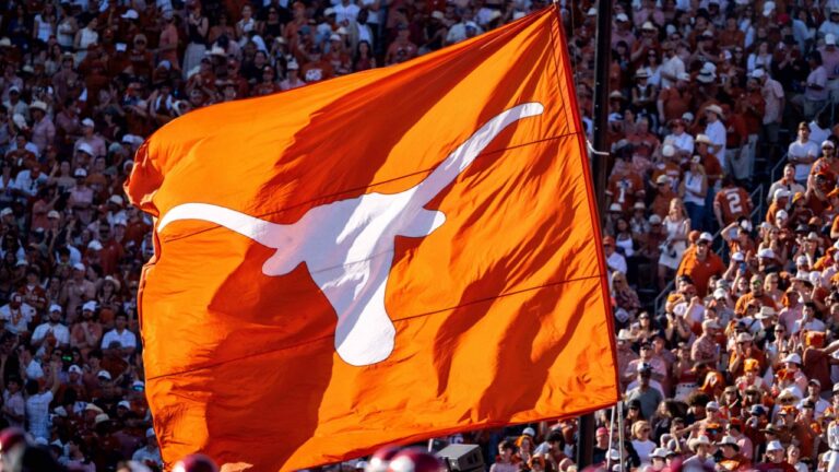 A Texas Longhorns flag is waved during the second half of an NCAA college football game between Texas and Oklahoma at the Cotton Bowl, Saturday, Oct. 11, 2025, in Dallas. Texas won 23-6. (Jeffrey McWhorter/AP)