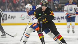Vancouver Canucks' Elias Pettersson (40) checks Edmonton Oilers' Connor McDavid (97) during the first period of an NHL hockey game in Vancouver, on Saturday, January 17, 2026. (Darryl Dyck/CP)