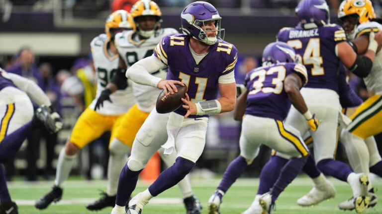 Minnesota Vikings quarterback Carson Wentz (11) rolls out of the pocket before throwing a pass during the second half of an NFL football game against the Green Bay Packers, Sunday, Sept. 13, 2026, in Minneapolis, Minn. (Abbie Parr/AP)