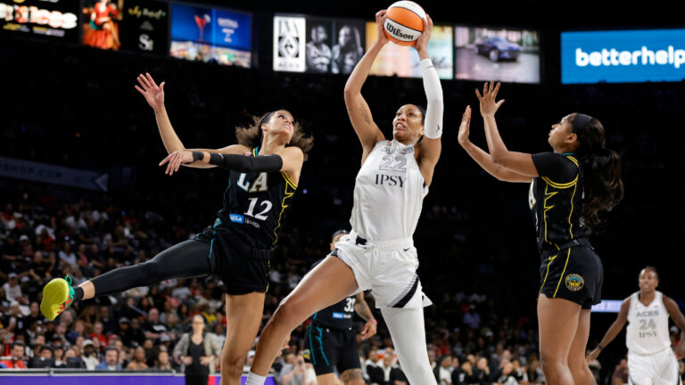 Las Vegas Aces center A'ja Wilson (22) makes a rebound between Los Angeles Sparks guards Rae Burrell (12) and Chance Gray during the first half of an WNBA basketball game Tuesday, Sept. 22, 2026, in Las Vegas. (Steve Marcus/Las Vegas Sun via AP)